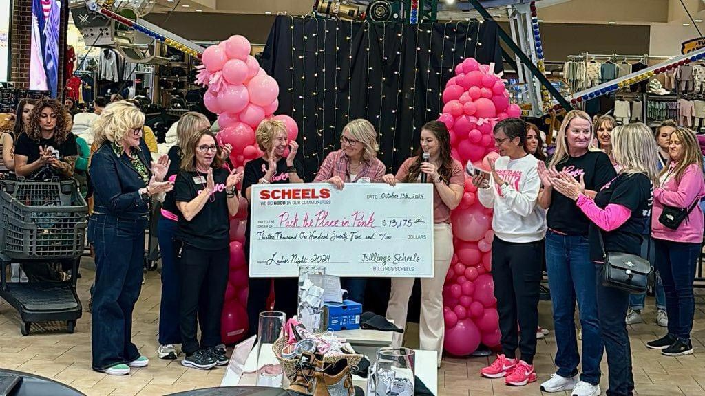 Pack the Place in Pink ladies accepting an oversize donate check