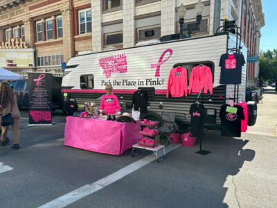 Pack the Place in Pink volunteers at a booth for the Chokecherry festival
